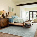 Light blue textured area rug in modern bedroom with wooden furniture