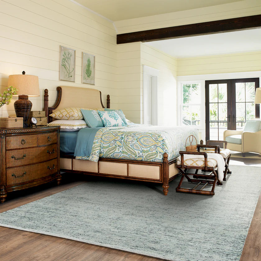 Light blue textured area rug in modern bedroom with wooden furniture