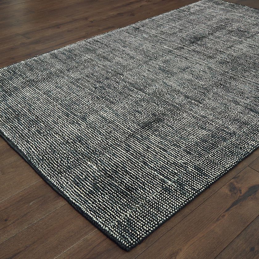 Modern gray textured rug with woven pattern on dark wood flooring