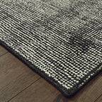 Modern gray textured rug with woven pattern on dark wood flooring
