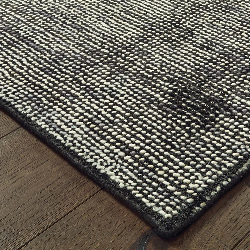 Modern gray textured rug with woven pattern on dark wood flooring
