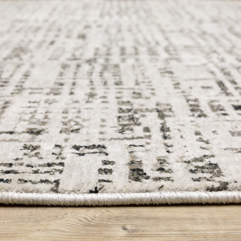 Modern geometric patterned rug in cream and brown tones on wood flooring
