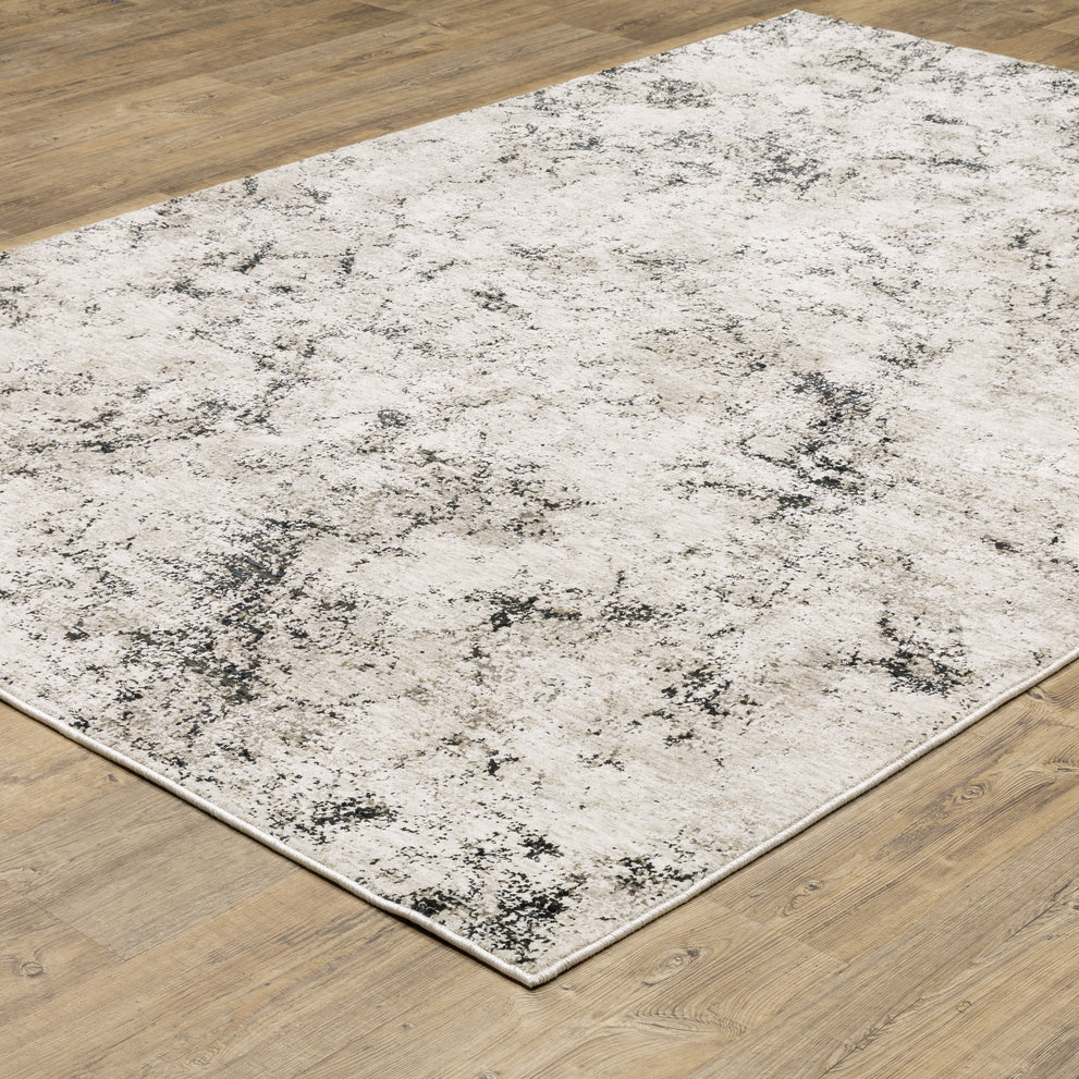Modern distressed rug with black speckled pattern on cream background texture