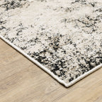 Modern distressed rug with black speckled pattern on cream background texture
