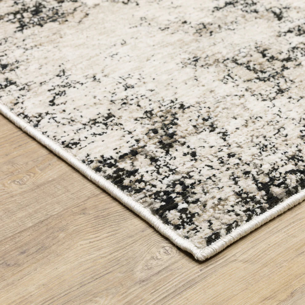 Modern distressed rug with black speckled pattern on cream background texture