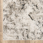 Modern distressed rug with black speckled pattern on cream background texture