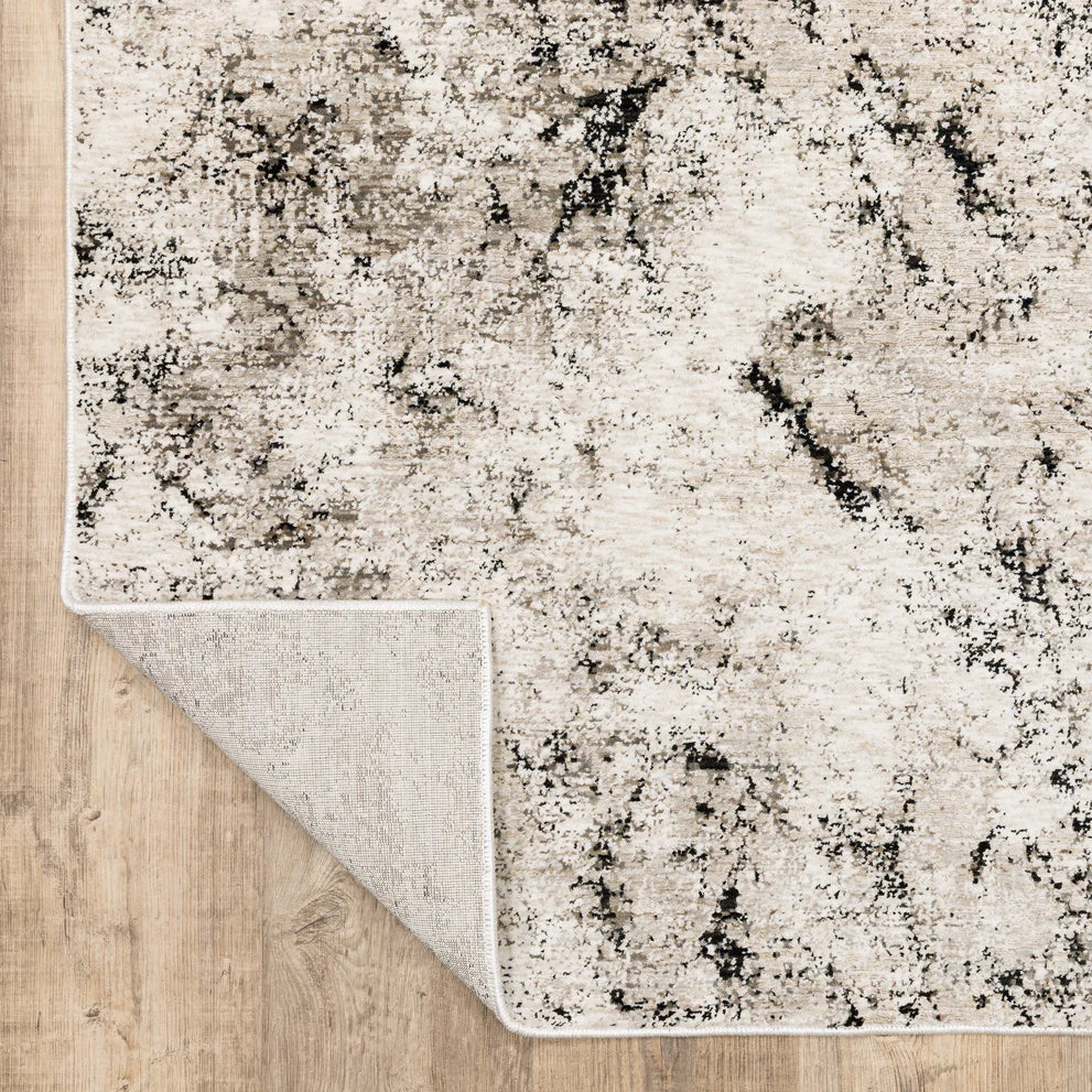 Modern distressed rug with black speckled pattern on cream background texture