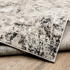 Modern distressed rug with black speckled pattern on cream background texture