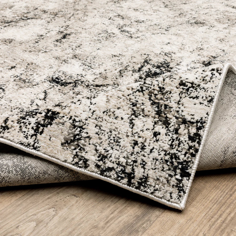Modern distressed rug with black speckled pattern on cream background texture