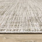 Beige textured area rug with abstract grid pattern on light wood flooring