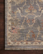 Gray traditional rug with floral pattern and ornate border in rust and gold tones