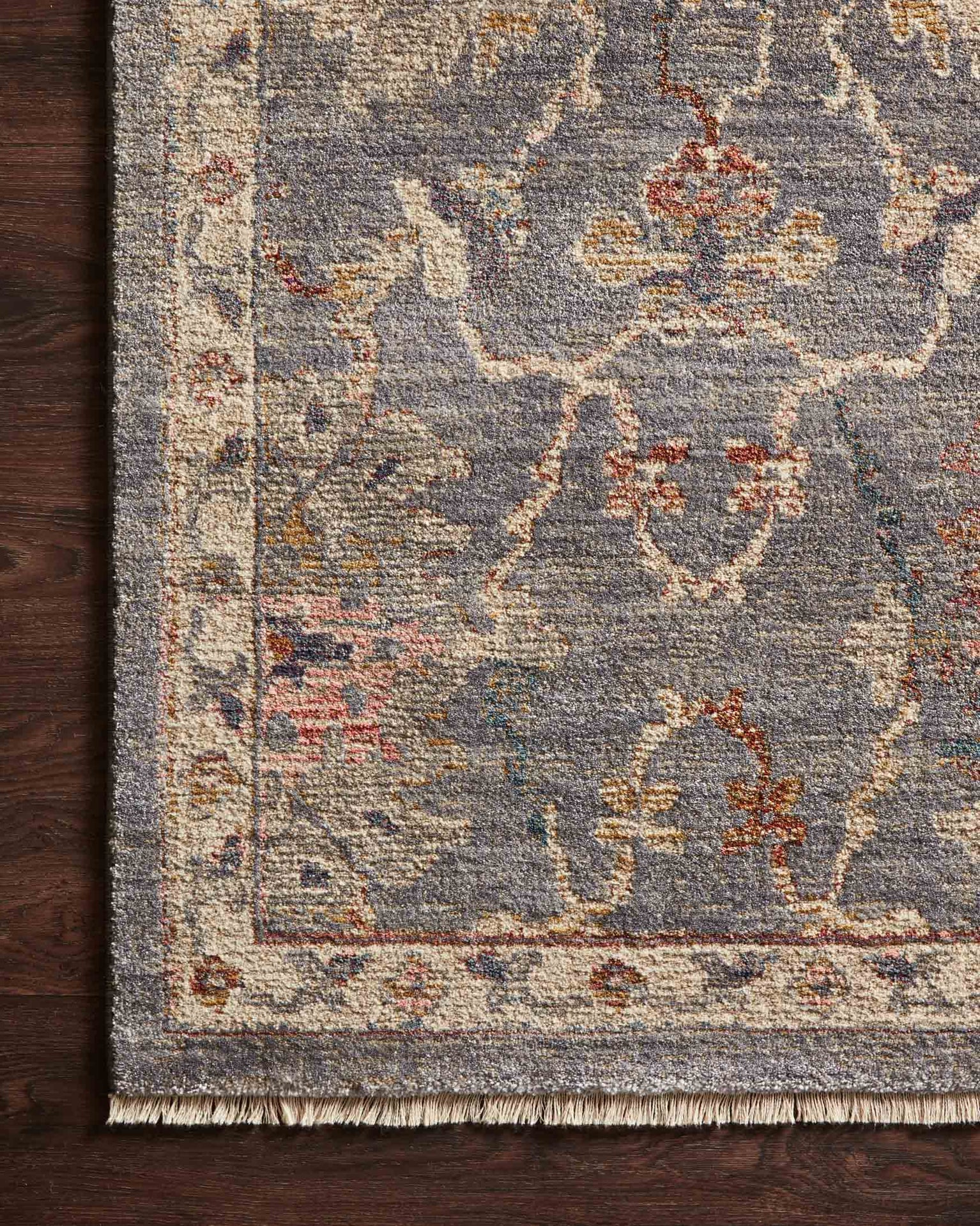 Gray traditional rug with floral pattern and ornate border in rust and gold tones