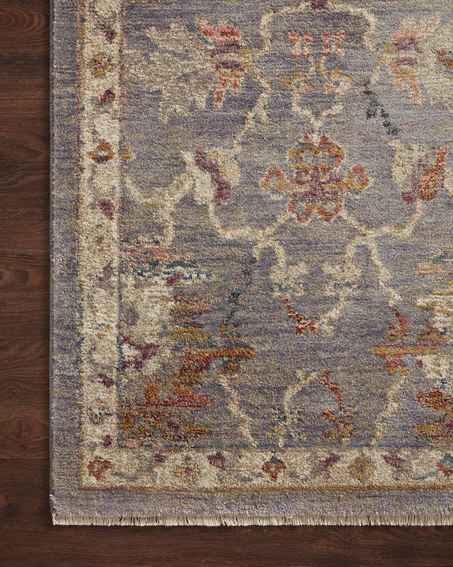 Gray traditional rug with floral pattern and ornate border in rust and gold tones