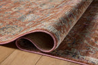 Vintage-style area rug with rust red background and ornate floral damask pattern in cream and blue tones
